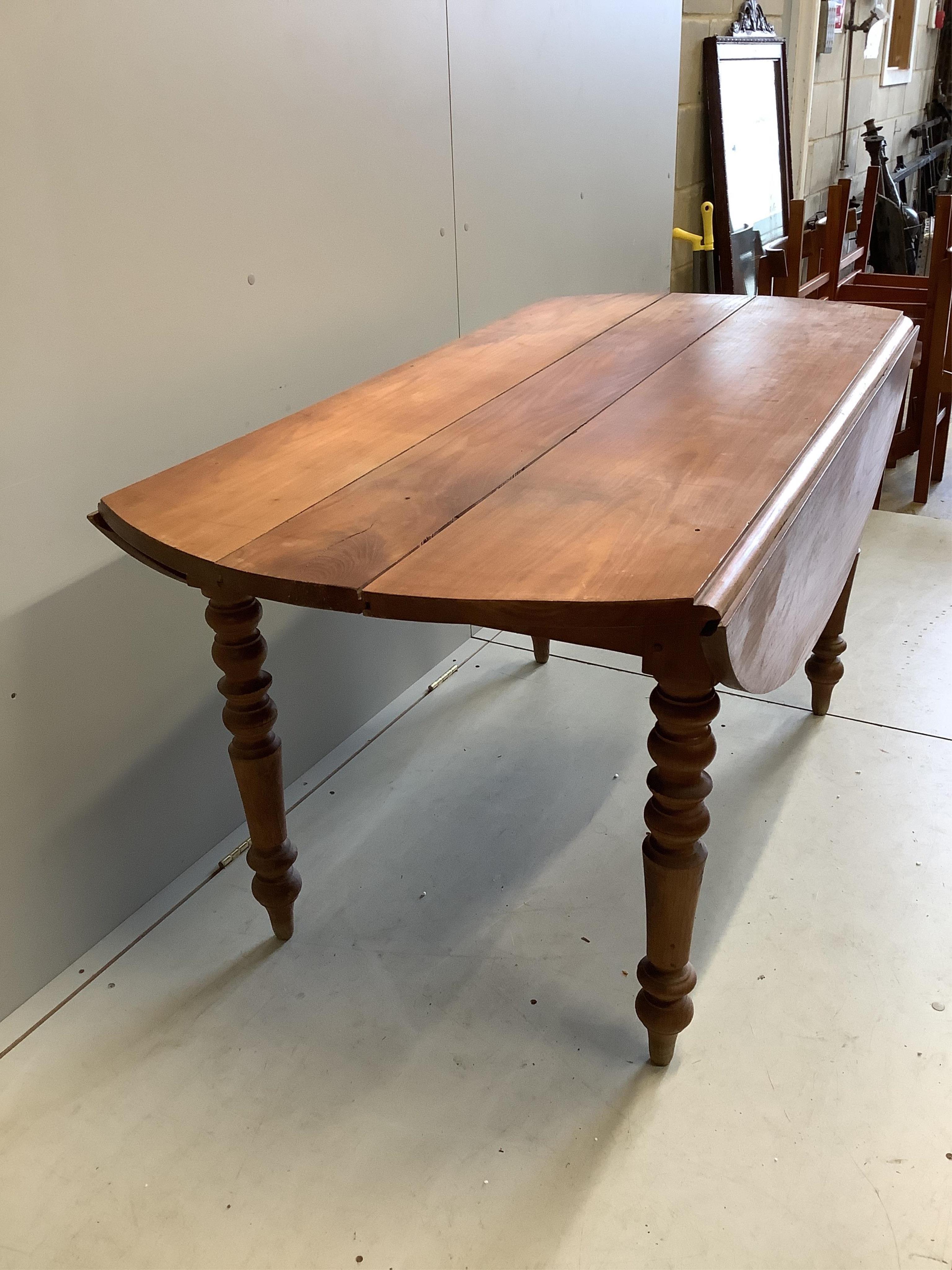 A 19th century French drop leaf cherry kitchen table, width 150cm, depth 75cm, height 74cm. Condition - poor